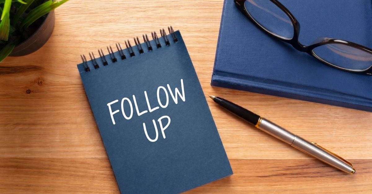 Bloco de notas com Follow Up escrito na mesa