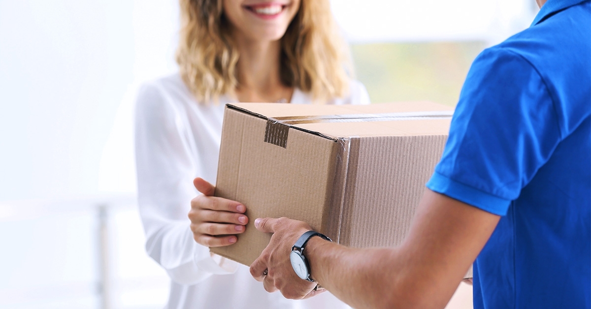 Mulher recebendo caixa em modalidade de entrega no mesmo dia do entregador